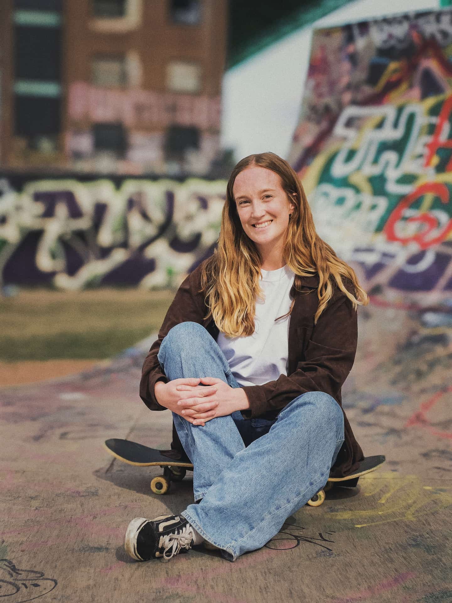 Linnéa seated smiling on her skateboard