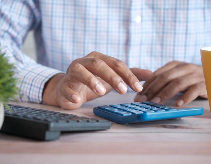 Close up picture of manly hands touching a calculator