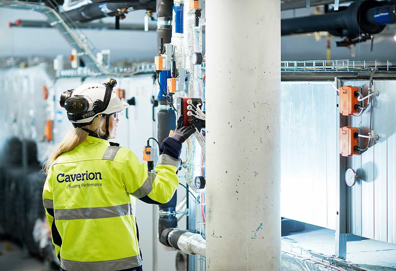 Caverion field worker checking equipment in a building