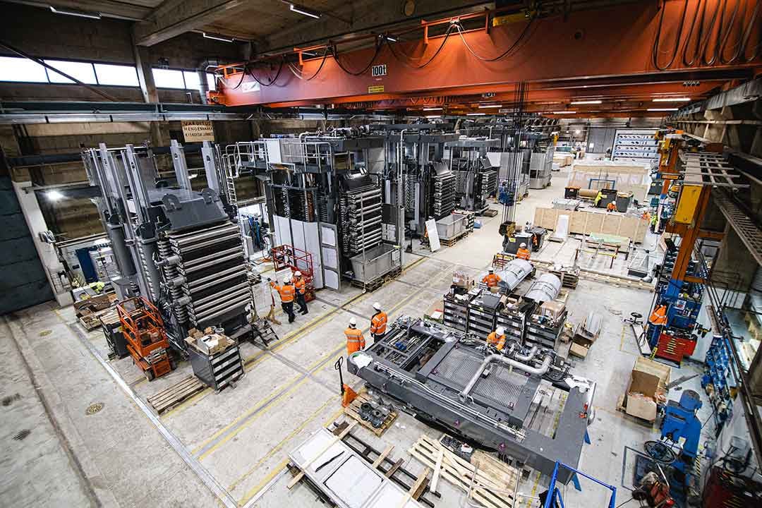 A large industrial building with industrial machinery and Metso's employees.