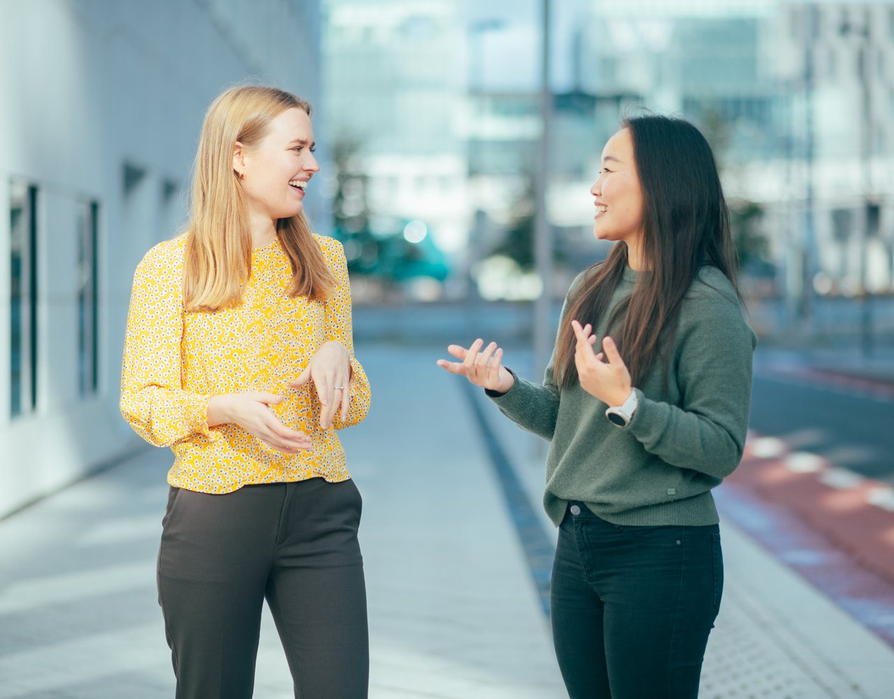two women stands outdoors and talking to each other