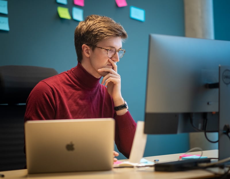 Mann jobber konsentrert foran en PC