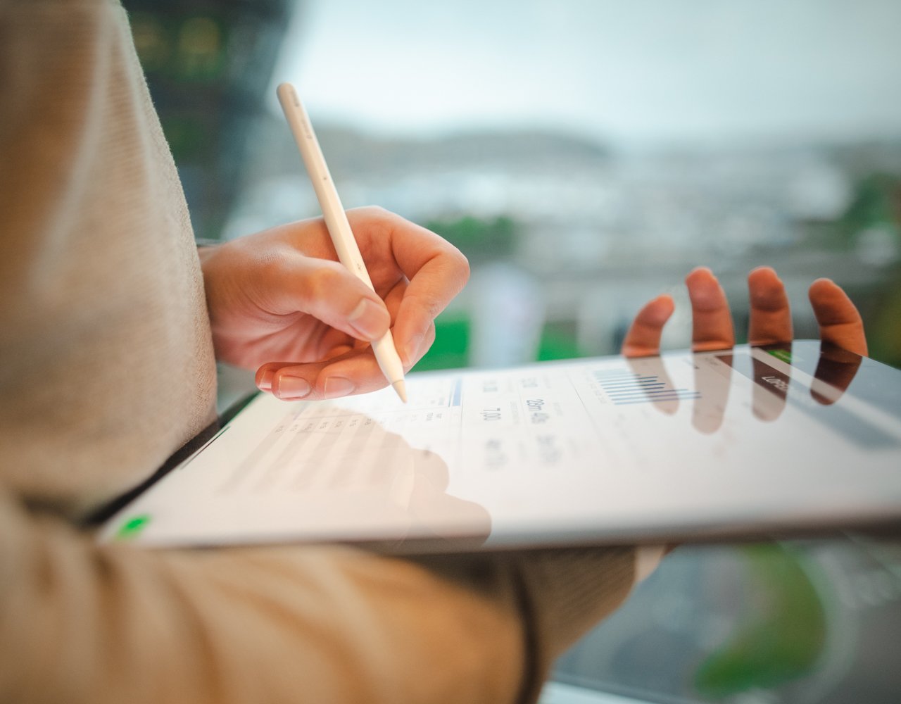 Nærbilde av en som skriver på en ipad