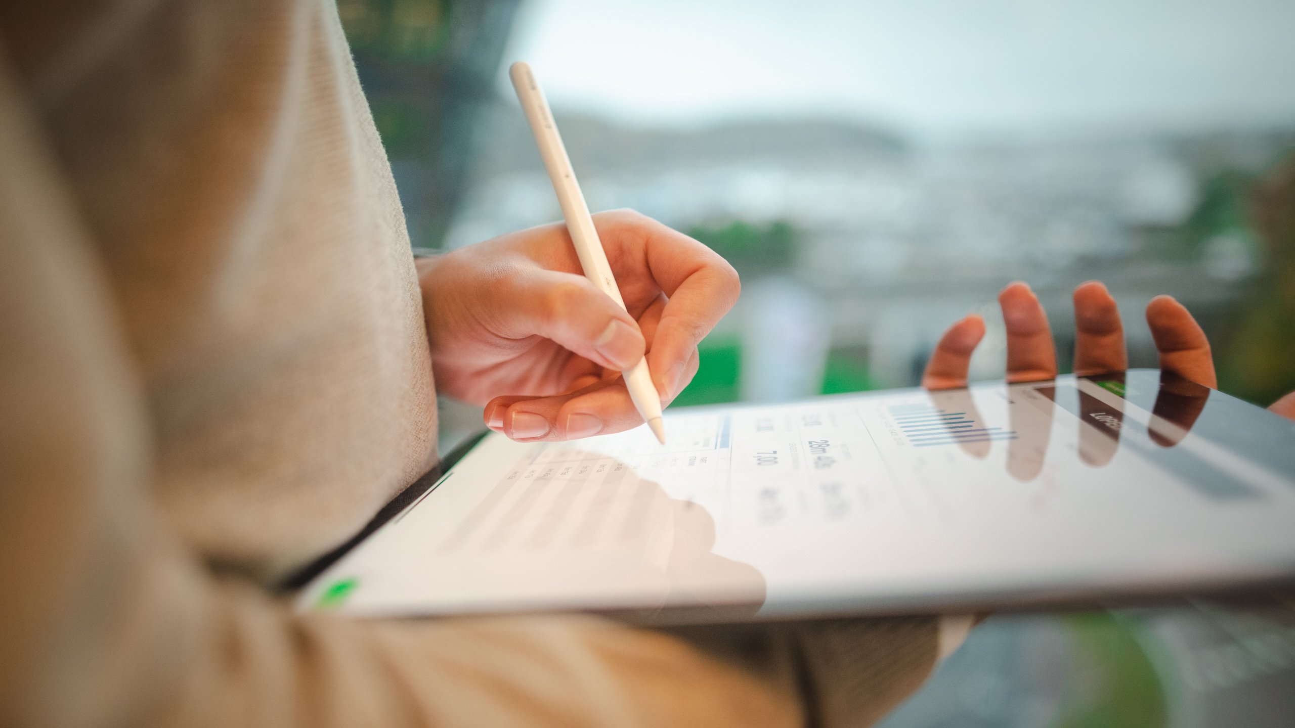 Nærbilde av en som skriver på en ipad